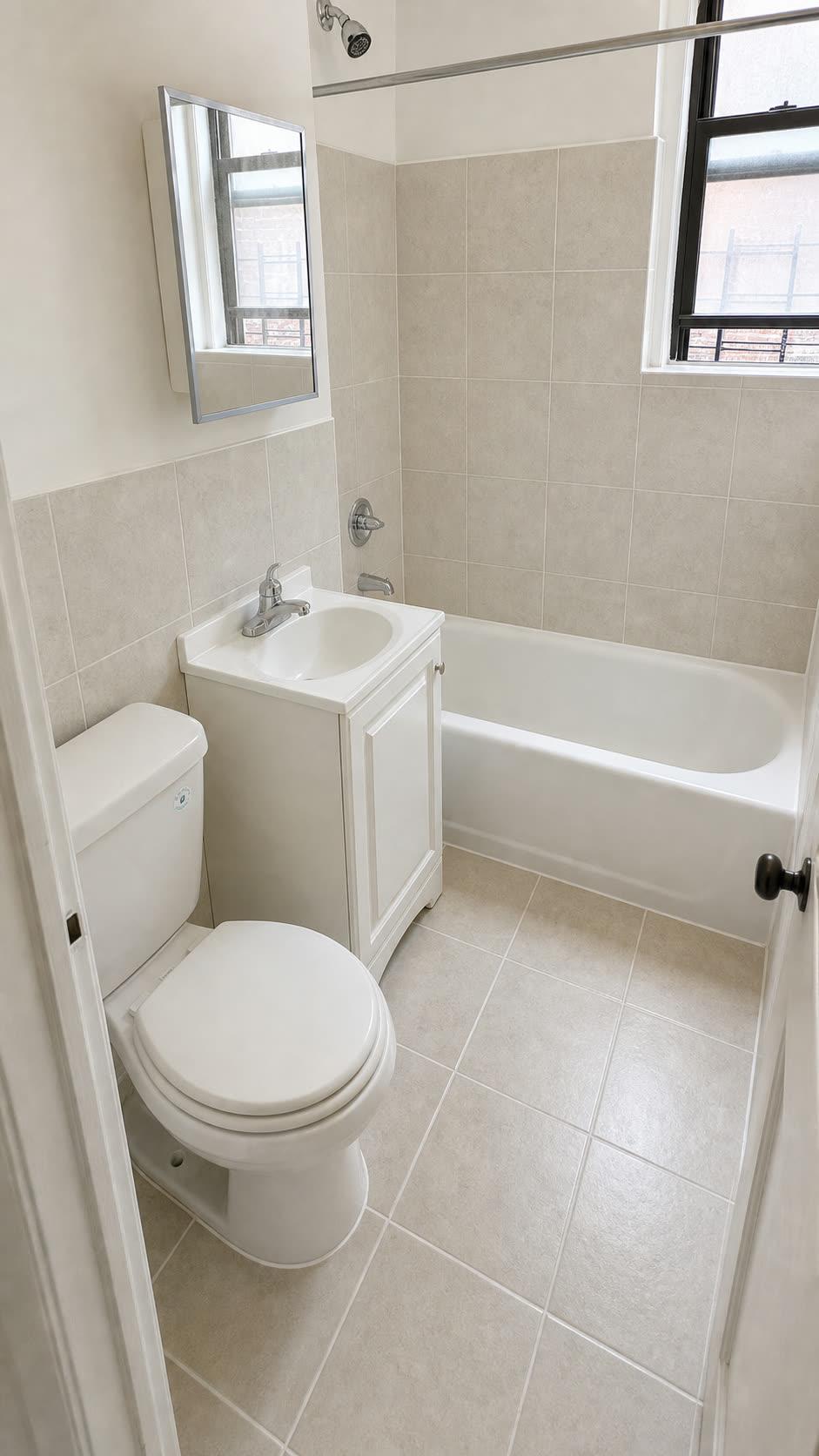 Bathroom after renovation — new tile, vanity, tub and fixtures